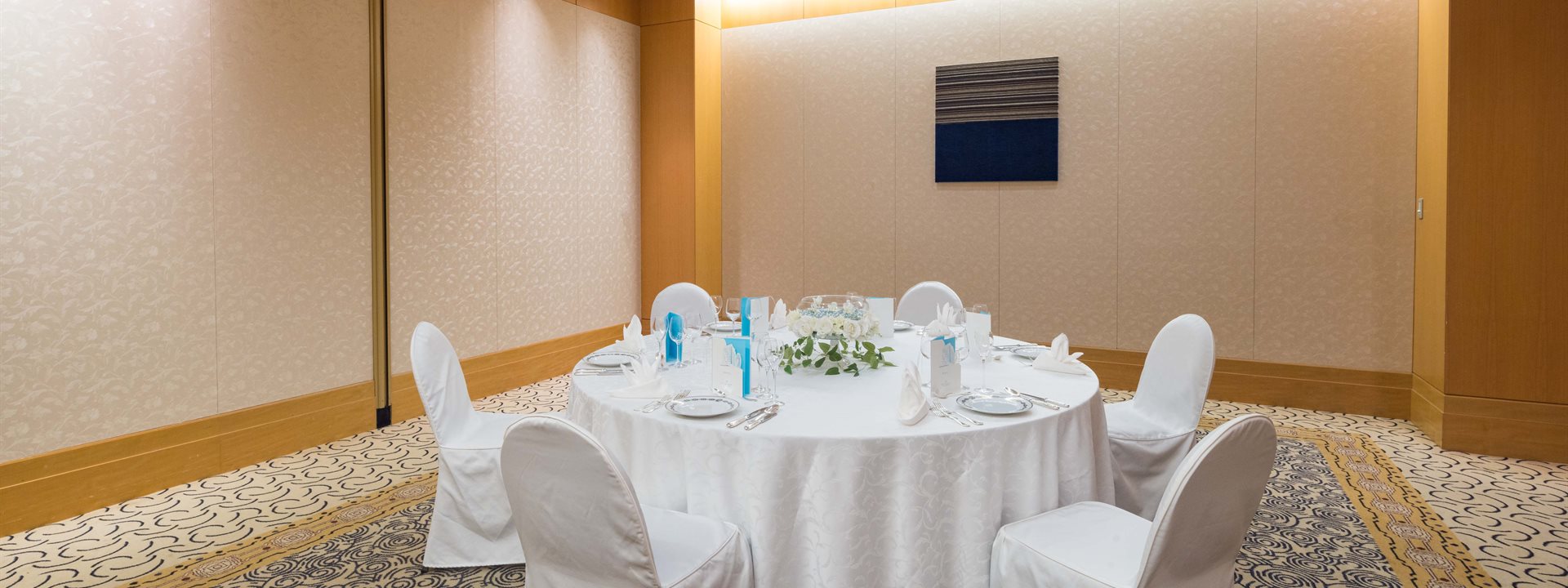 "Hamayuu" is a small banquet hall located on the second basement floor of the Yokohama Bay Hotel Tokyu. Six chairs are arranged around a round table that has been set for a formal dinner.