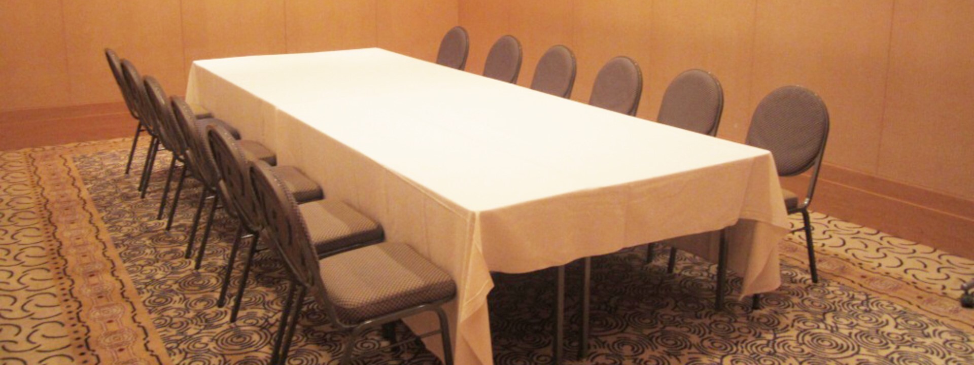 "Sazanka" is a small banquet hall located on the second basement floor of the Yokohama Bay Hotel Tokyu. Six chairs are arranged around a round table that has been set up for a formal dinner.